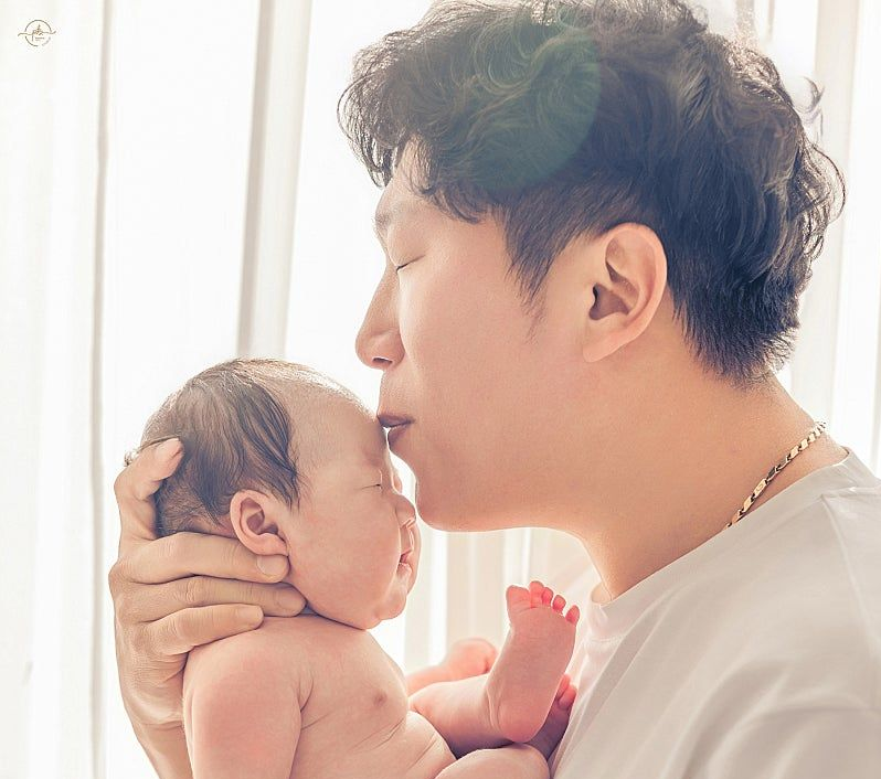 Park Seong-bae (right), a 41-year-old from Busan who died on Jan. 30, kisses his newborn daughter on the forehead. (Korea Organ Donation Agency)